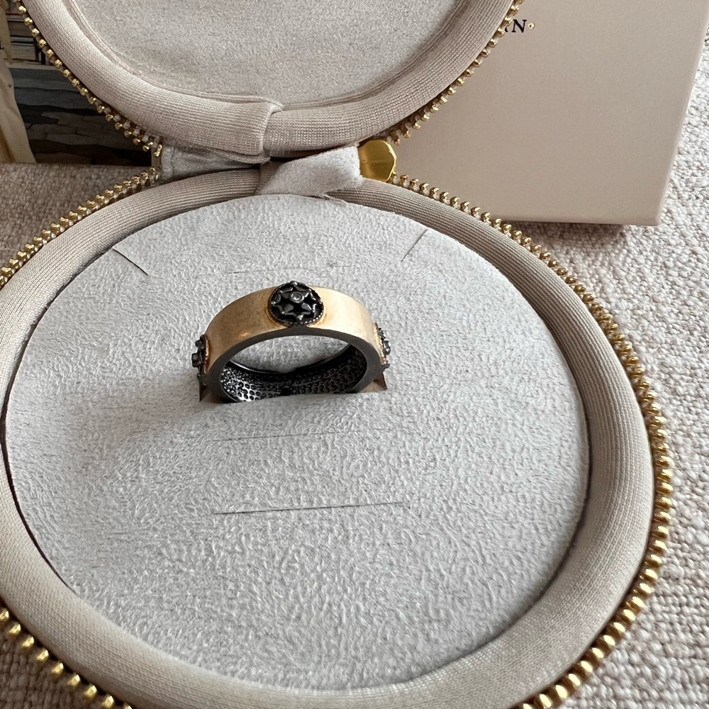 Freida Rothman Gold-Tone Band Ring with Black FR flower symbol.
